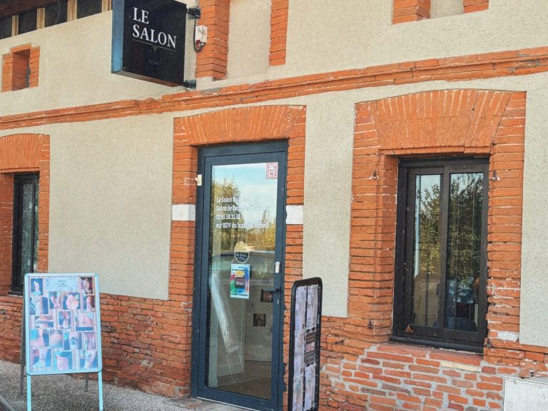 Salon de tatouage. Façade d'un bâtiment avec des briques, une porte vitrée et un panneau "Le Salon by Sev".