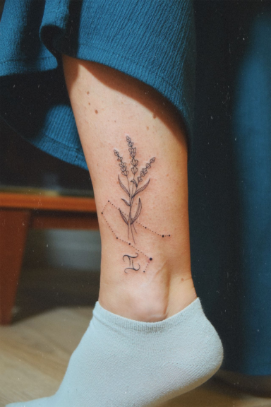 Tatouage de lavande avec une costallation astrologique gémeaux sur la cheville, avec une de chaussette blanc et un pantalon bleu roi.